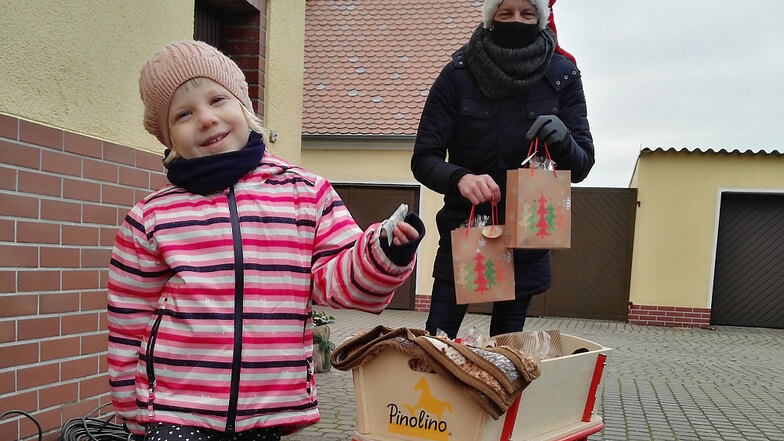 Ortsvorsteher Jens Kieschnick und seine Tochter Elisa, die gewissermaßen als Weihnachtswichtel fungierte, waren mit Bollerwagen und Geschenken unterwegs.