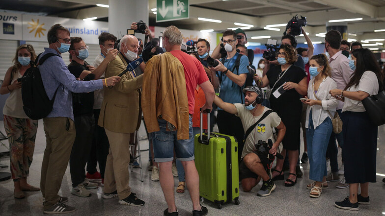 Wie ein Popstar: Ein Fluggast von Flug TUI X3 2312 Düsseldorf-Mallorca wird am Montag im Flughafen von Palma von Journalisten interviewt.