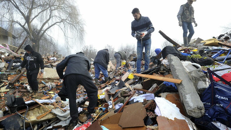 Kroatien, Poljana: Menschen durchsuchen die Trümmer von eingestürzten Häusern.