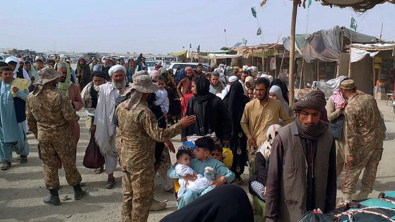 Pakistanische Soldaten überprüfen die Papiere von Menschen, die die Grenze zu Afghanistan an einem Grenzübergang überqueren. Experten rechnen angesichts der Situation in Afghanistan mit vielen Flüchtlingen.