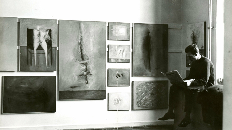 Atelierwand mit Werken von Gerhard Richter während des Semesterrundgangs an der Düsseldorfer Kunstakademie im Februar 1962; rechts sitzend Manfred Kuttner, mit dem er im September 1962 die erste Ausstellung in Fulda hat.