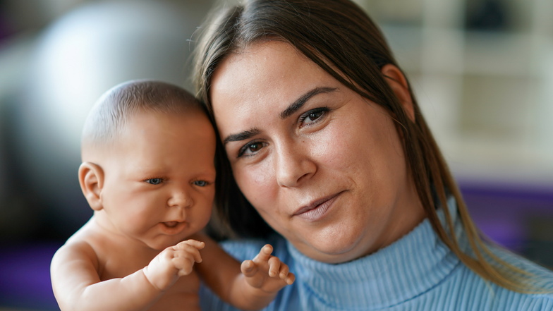 Adelina Ajeti mit einer Säuglingspuppe in der Hebammenpraxis .