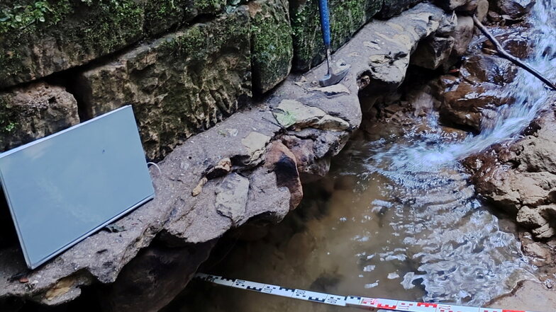 An die zwei Meter soll die Straße an der Sandsteinmauer unterspült sein.