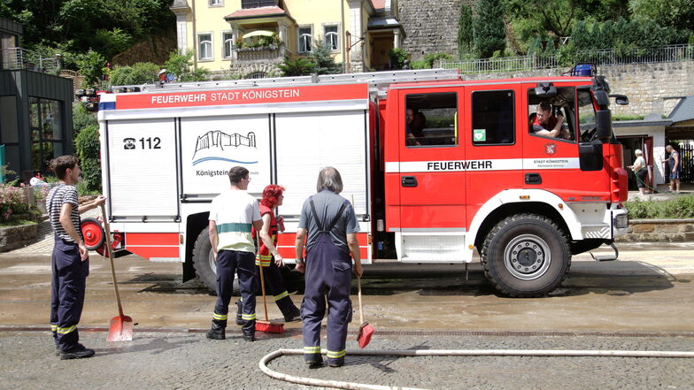 Aufräumen im Kirnitzschtal: Einsatzkräfte der Feuerwehr Königstein helfen in Bad Schandau, die Talstraße zu beräumen.