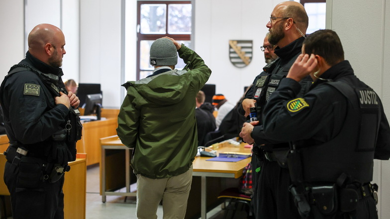 Einer der sechs Angeklagten (M) kommt vor Prozessbeginn im Zusammenhang mit Ausschreitungen und rassistischen Angriffen im Spätsommer 2018 ins Landgericht Chemnitz.