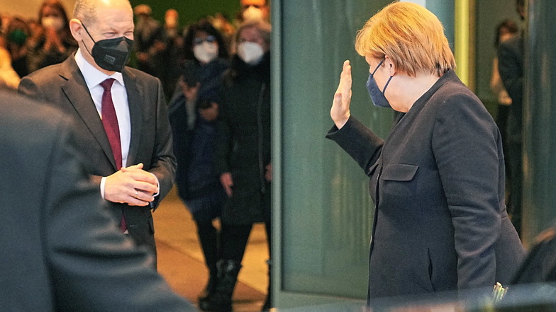 Angela Merkel winkt zum Abschied nach der Amtsübergabe an den neu gewählten Bundeskanzler Olaf Scholz (SPD, l) im Bundeskanzleramt.