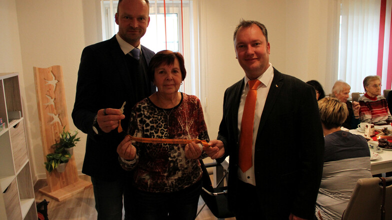 Sven Viehrig (links) und Tino Hütter übergeben den Schlüssel für die Begegnungsstätte der WGF in Hartha an Karin Cvancara.