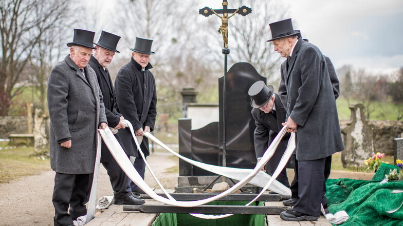 "Man tut ein gutes Werk": Vor der Beisetzung bereiten die Sargträger die Grabstelle vor und legen die Senkbänder bereit.