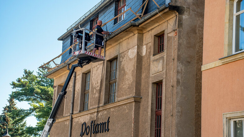 Am Gebäude der ehemaligen Post in Waldheim lässt der Eigentümer das Dach sichern. Wegen herabfallender Schiefer und anderer Dachelemente hatte die Kommune den Fußweg absperren lassen.