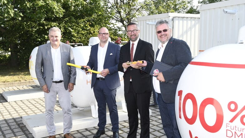 Andreas Servatius, Stefan Schmidt (beide von Primagas), Wirtschaftsminister Martin Dulig und Andreas Rimkus (v.li.) von der SPD-Fraktion im Bundestag vor der Anlage, in der die Wirkung von Bio-Flüssiggas getestet wird.