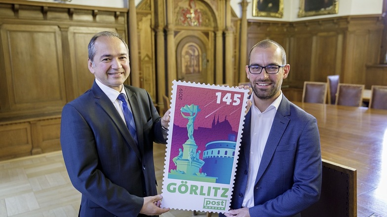 Ins Rathaus brachte Alexander Hesse eine größere Variante der neuen Briefmarke mit. OB Octavian Ursu freut sich, dass die Wahl auf Görlitz fiel.
