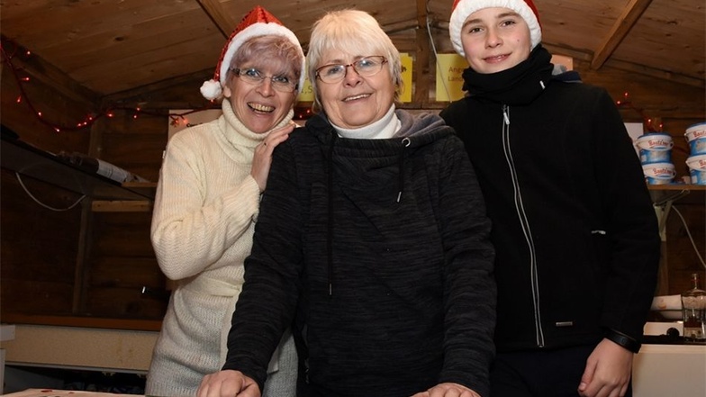 Annette Tschirch, Roselies Nitsche und Lennard Menzel (von links) verkaufen Glühwein und Kinderpunsch.