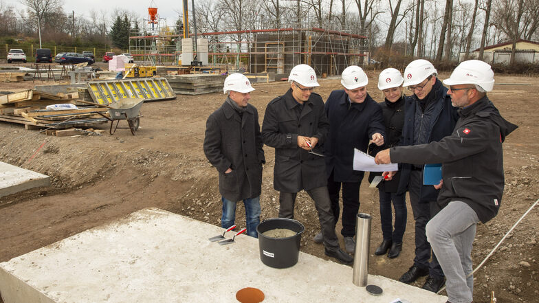 Bauherren, beteiligte Firmen und die Bürgermeister von Coswig und Weinböhla haben den Grundstein gelegt und eine Plombe mit den Planungsunterlagen für den neuen Firmensitz von Novus air versenkt.