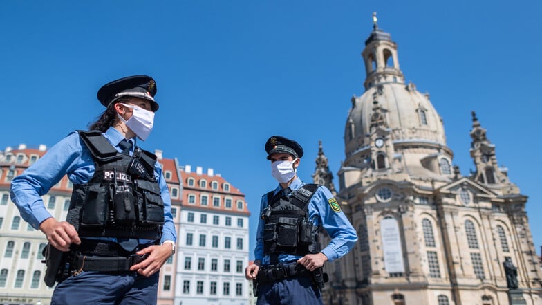 Polizisten stehen auf dem Neumarkt vor der Frauenkirche. In der Kirche finden weiterhin keine Gottesdienste statt.