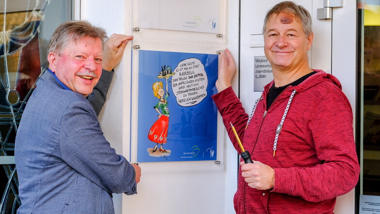 Oberbürgermeister Bert Wendsche (l.) und Sternwarten-Leiter Ulf Peschel bringen das Hinweisschild am Eingang an.