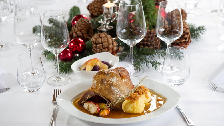 Schmecken lassen: Ein Stück von der Weihnachtsgans zusammen mit Klößen auf dem Teller ist der Klassiker für die festlich geschmückte Tafel.