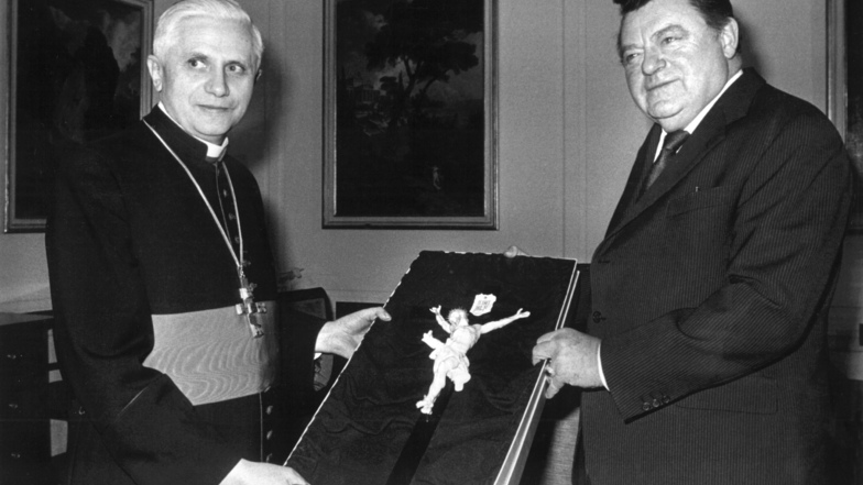 12.02.1982 Der damalige bayerische Ministerpräsident Franz Josef Strauß (r) überreicht als Abschiedsgeschenk ein Kruzifix aus Porzellan an den damaligen Erzbischof von München und Freising, Joseph Kardinal Ratzinger (l).