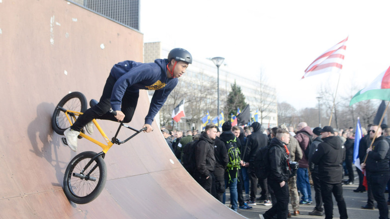 Ein junger Fahrradfahrer übt neben der Neonazi-Demo seine Tricks.