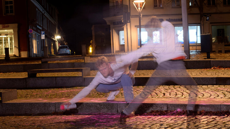 Sie tanzt, er sprüht. Jana Schmück und Patrick von Bardeleben haben am Sonntagabend die Aktion "Invisible Dances" auf dem Altmarkt in Bischofswerda und vor dem ehemaligen Kino umgesetzt.
