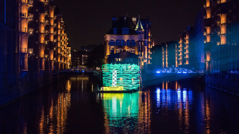 Greenpeace-Aktivisten projizieren in Hamburg die mögliche Höhe des Wasserstands zum Ende des Jahrhunderts auf das Wasserschloss.