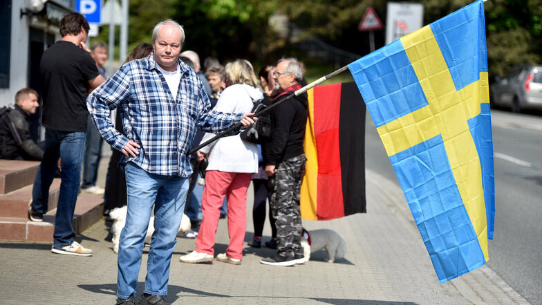 Dieser Mann hält die Schwedenfahne in der Hand, weil Deutschland sich seiner Meinung nach an dem Land ein Beispiel nehmen könnte. 