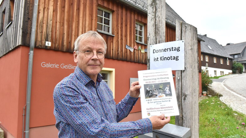 Karsten Franz bringt am Bärensteiner Geislerhaus das Werbeplakat für die nächste Studiokino-Vorführung an.