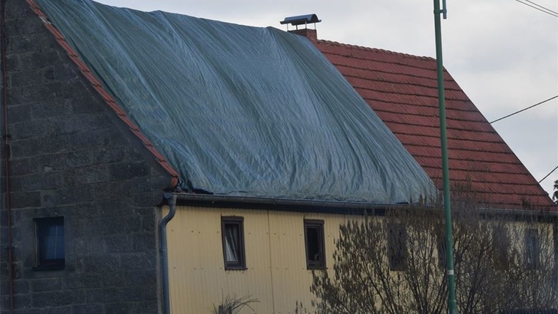 Das kaputte Dach des Hauses an der Dürrröhrsdorfer Straße ist jetzt mit einer Plane abgedeckt.