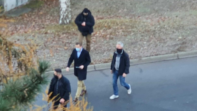 Mit einem Tablet in der Hand und Leibwächtern um ihn herum, geht Nawalny (Mitte) um den Block.