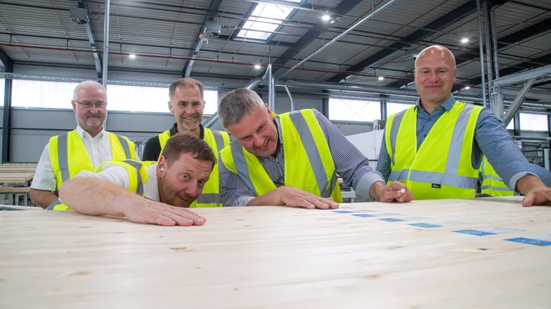 Ministerpräsident Michael Kretschmer (CDU, vorn l.) schaute am Dienstag im Sägewerk HS Timber in Kodersdorf ganz genau hin. Mit dabei Landtagskandidat Tilmann Havenstein (CDU, 2.v.r.),  Bürgermeister René Schöne (CDU, l.) und Werkleiter Thomas Kienz (r.)