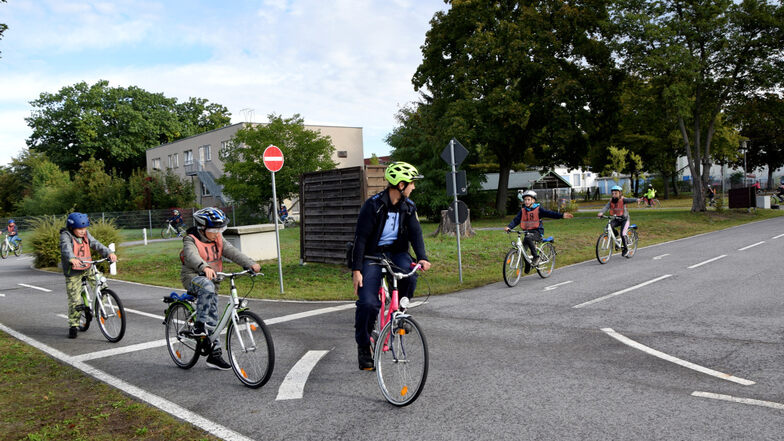 Schüler lernen unter Anleitung, welche Regeln im Straßenverkehr beachtet werden müssen. Das praktische Radfahren im Verkehrspark wird durch eine schriftliche Arbeit ergänzt.