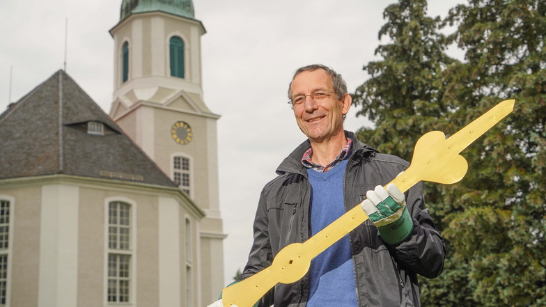 Marko Mitzscherling, Pfarrer der Kirchgemeinde Uhyst a.T., hält hier den Minutenzeiger der Turmuhr noch in der Hand. Inzwischen wurde er montiert.
