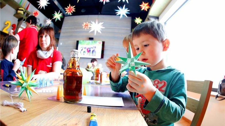 Der fünfjährige Emile aus Großdubrau bei Bautzen baut sich einen grüngelben Stern aus Kunststoff.