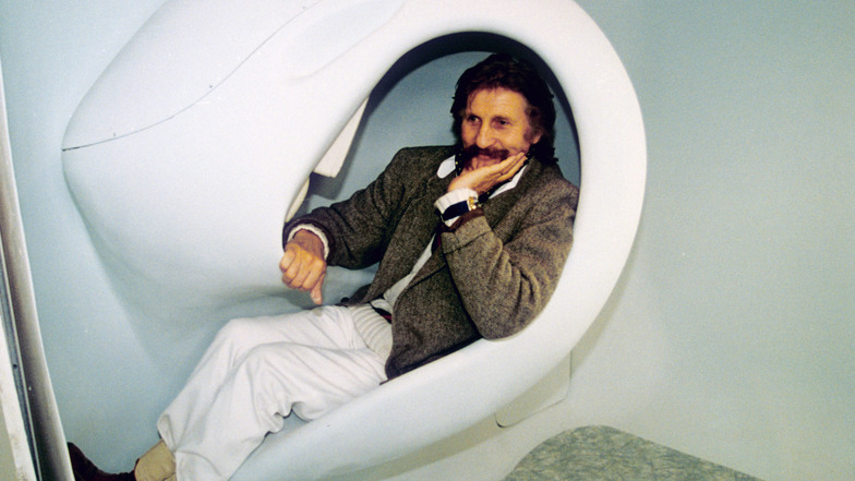 Luigi Colani liegt in einem Sitzmöbel des von ihm gestylten "Habitaner", einem Wohnmodul für Einzelpersonen. 