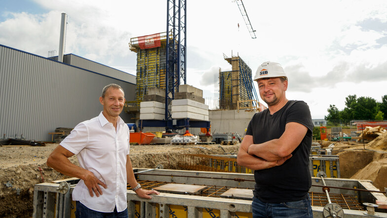 Ionisos-Geschäftsführer Henry Mitschak (l.) steht mit Bauleiter Sandro Hoffmann vor der neuen Halle, die auf dem Werksgelände im Industriegebiet Salzenforst entsteht.