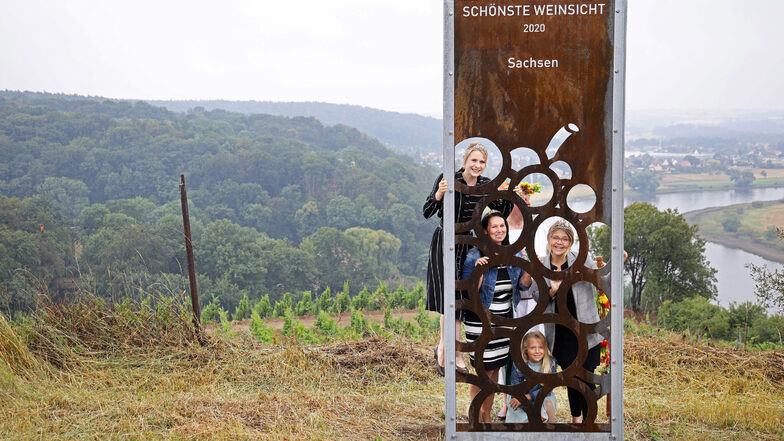 Sachsens Weinkönigin Katja Böhme (links unten) mit ihrer Tochter Lilli, die sächsische Weinprinzessin Ann-Kathrin Schatzl (links oben) und die Diesbar-Seußlitzer Ortsweinkönigin Lisa-Marie Queißer sind die Ersten, die durch die Stele blicken.