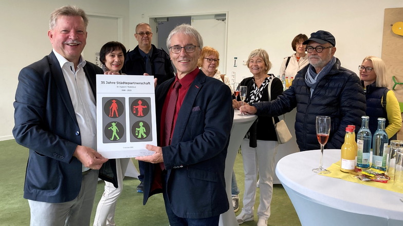 OB Bert Wendsche (l.) bekam das Geschenk von St. Ingberts Ersten Beigeordneten, Albrecht Hauck, als Bild überreicht. Dieses zeigt die Ampelmännchen.