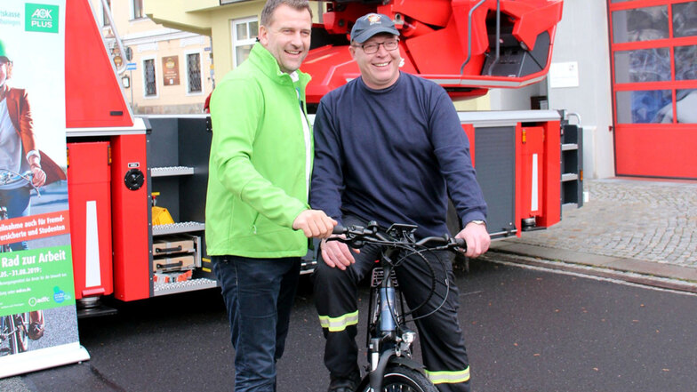 Übergabe vor der Arbeitsstelle: An der Feuerwehr in Zittau erhielt René Girbig das E-Bike von Rene Kindermann.
