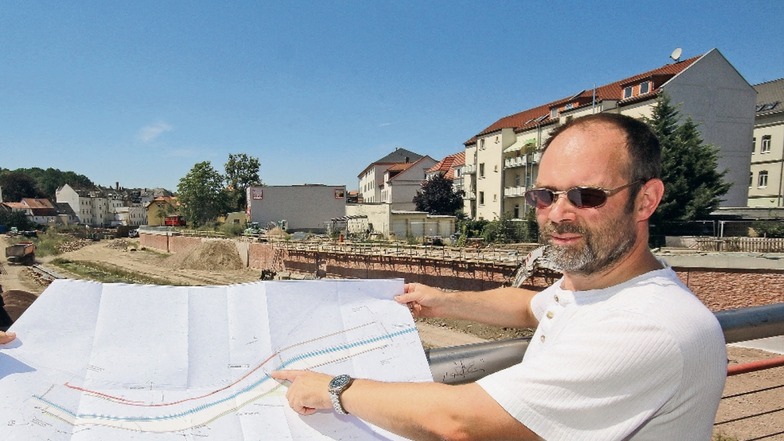 Thomas Zechendorf von der Landestalsperrenverwaltung erklärt auf einem Plan den Baufortschritt der Flutmulde zwischen der Straße des Friedens und der Johannisstraße.