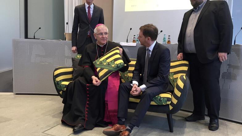 Ministerpräsident Michael Kretschmer hat zur offiziellen Vorstellung der Veranstaltungsreihe mit Bischof Heinrich Timmerevers auf dem Sachsensofa Platz genommen. 