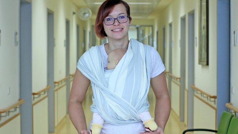 Richtig: Klinikum-Mitarbeiterin Yvonne Schenke zeigt, wie das Baby richtig getragen wird. Beinchen und Po bilden ein M.