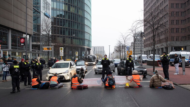 Mitglieder der Umwelt-Gruppe Letzte Generation blockieren die Straße am Potsdamer Platz.