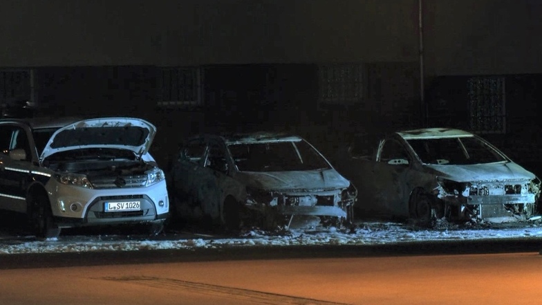 Drei von einem Feuer beschädigte Dienstfahrzeuge der Polizei Leipzig stehen auf dem Dienstgelände im Stadtteil Leutzsch.