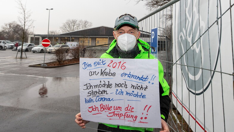 Ulf Buchholz aus Freital demonstriert mit einem Plakat vor dem Impfzentrum in Pirna.