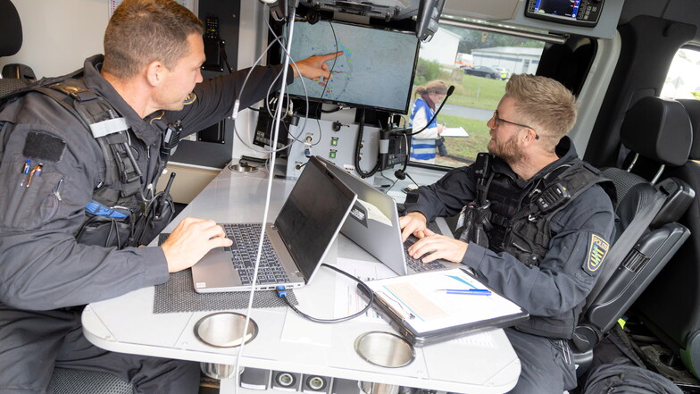 Die beiden Polizeibeamten André Kießling (links) und Robin Marschner in der Befehlsstelle am ersten Einsatztag der neuen Maßnahmen.