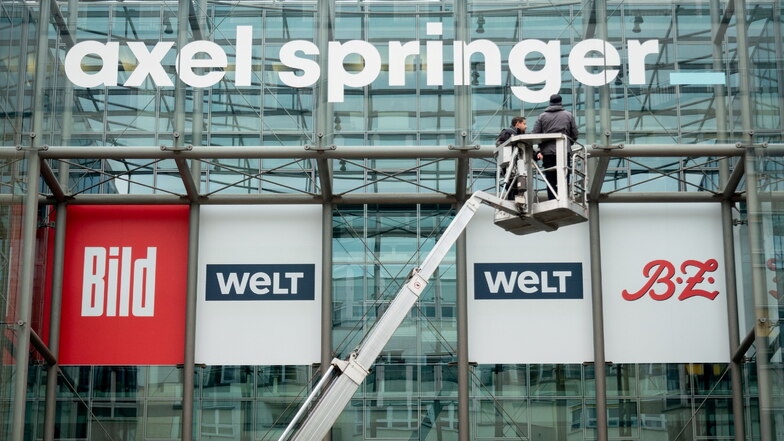 Arbeiter bringen in Berlin ein neu gestaltetes Logo des Medienkonzerns Axel Springer über der Axel Springer Passage an.