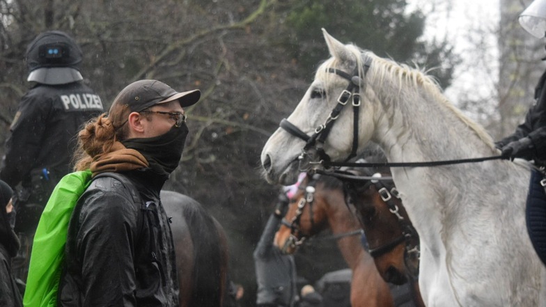 Auge in Auge: Vermummter Gegendemonstrant vor einem Pferd der Polizeireiterstaffel.