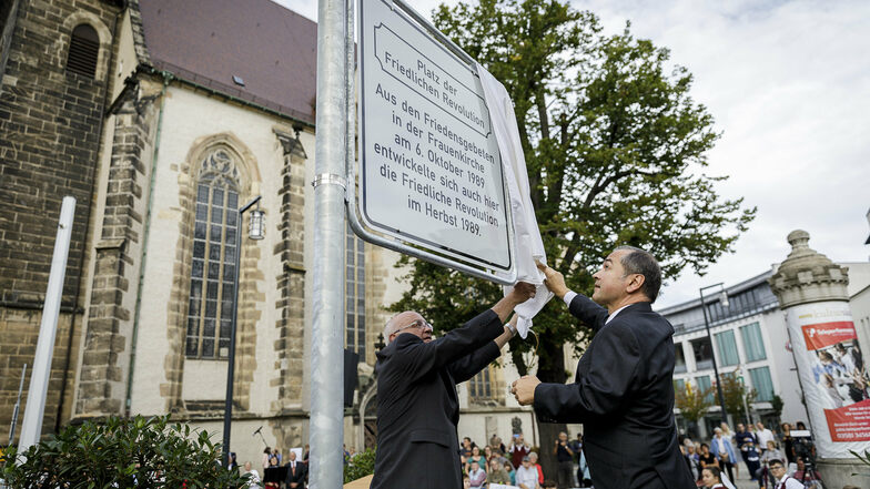 Der frühere Frauenkirchen-Pfarrer Albrecht Naumann und Oberbürgermeister Octavian Ursu enthüllen das neue Schild.