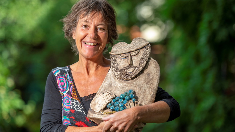 Die Keramikkünstlerin Ines Hoferick hält die Tonskulptur Winzer fest in ihrem Arm. Auf Schloss Wackerbarth zeigt sie ihre neuesten Kreationen.