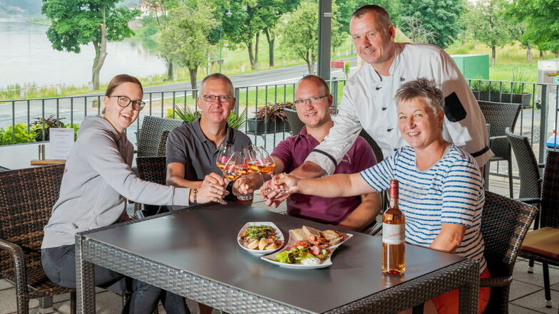 Familie Ulrich und ihr Koch Karsten Simon stoßen auf den Neubeginn an.
