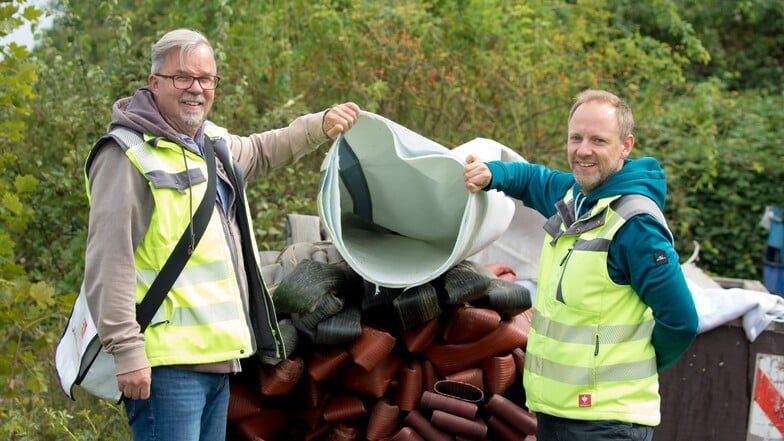 Teamleiter Norman Wonka (l.) und Projektleiter Daniel Philipp von der Stadtentwässerung freuen sich, dass der Abwasserkanal am Mittelsteg im Kaitzbachtal jetzt saniert ist. Hier zeigen sie ein restliches Stück des Inliners, mit dem er abgedichtet wurde.